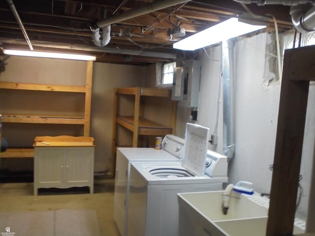 clothes washing area with electric panel, a sink, laundry area, and washer and clothes dryer