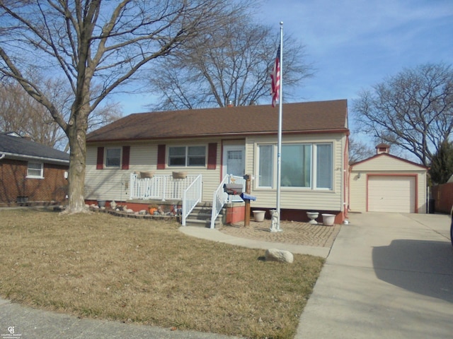 view of front of property featuring an outdoor structure, a garage, driveway, and a front lawn