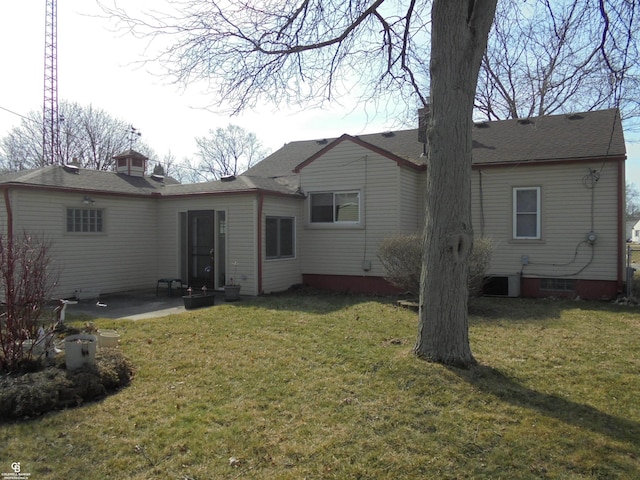 rear view of property with a lawn, a chimney, a patio, and roof with shingles