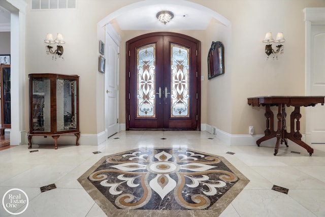 entrance foyer featuring visible vents, arched walkways, baseboards, and french doors