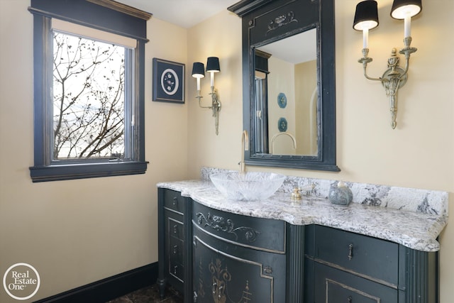 bathroom featuring a wealth of natural light, baseboards, and vanity