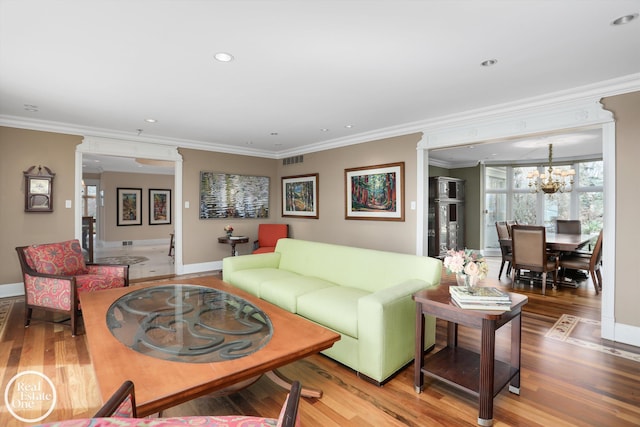 living area featuring visible vents, baseboards, an inviting chandelier, and wood finished floors