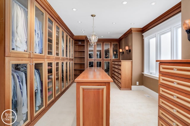 walk in closet with a notable chandelier and light colored carpet