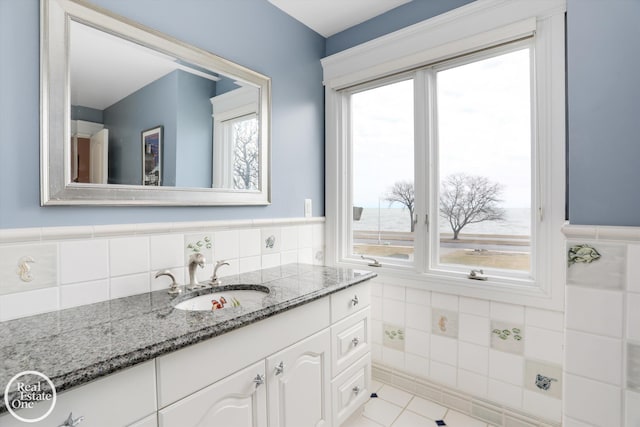 bathroom with vanity, tile walls, a wainscoted wall, and tile patterned floors