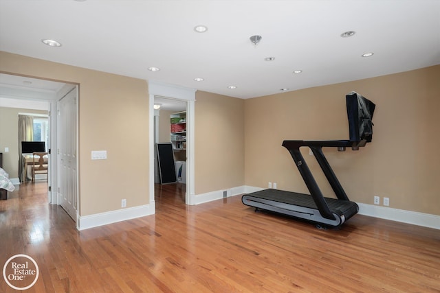 exercise room with recessed lighting, baseboards, and light wood finished floors