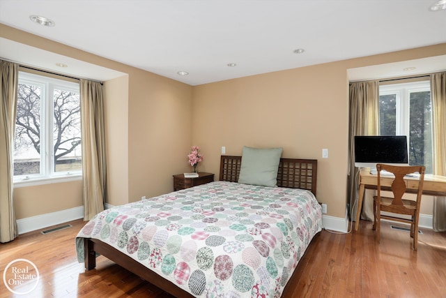 bedroom with recessed lighting, wood finished floors, visible vents, and baseboards