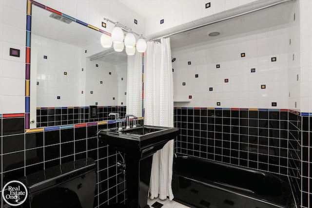 bathroom featuring tile walls and shower / tub combo