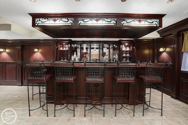 bar featuring light tile patterned floors and a community bar