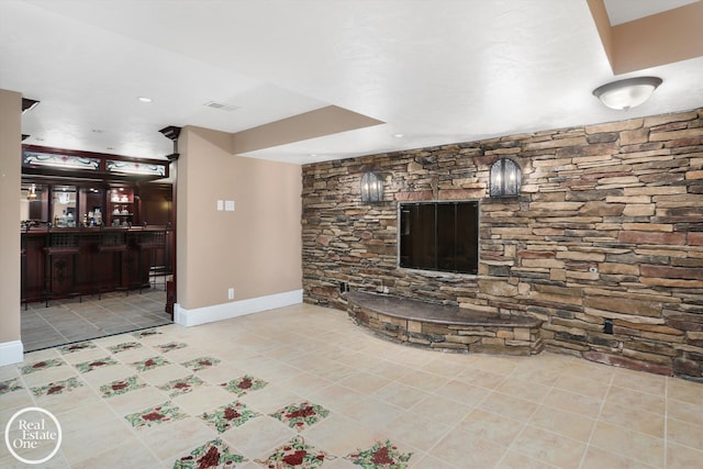 living area with visible vents, baseboards, and tile patterned flooring