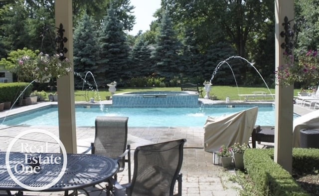 view of swimming pool featuring a patio and a pool with connected hot tub