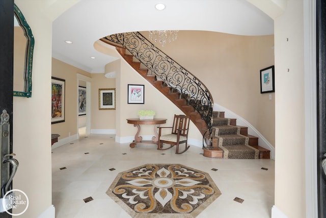 tiled foyer featuring recessed lighting, arched walkways, an inviting chandelier, baseboards, and stairs