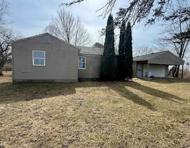 back of house with an outbuilding and a lawn