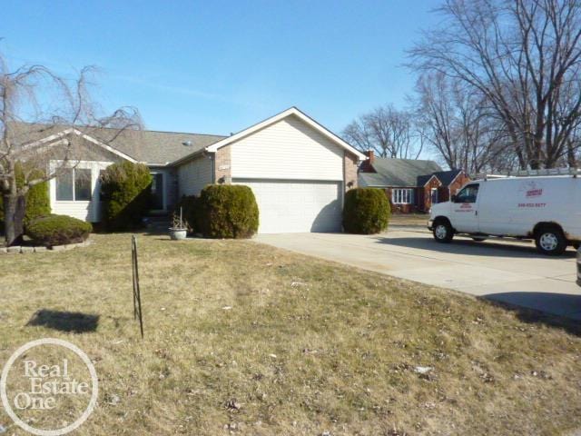 ranch-style home with driveway, a front lawn, and an attached garage