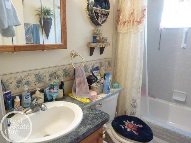 bathroom with toilet, vanity, and shower / bathtub combination with curtain