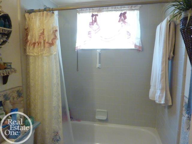 bathroom with shower / bath combo with shower curtain