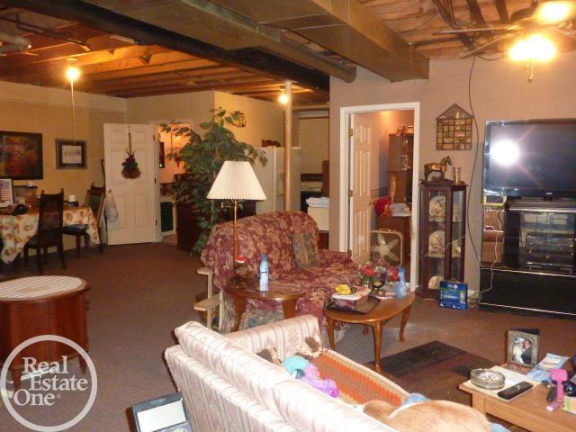 carpeted living area with beamed ceiling