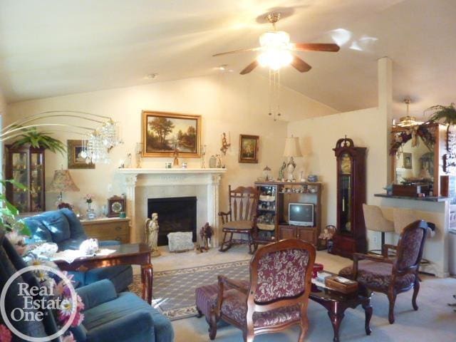 living area featuring carpet floors, ceiling fan, a fireplace, and vaulted ceiling