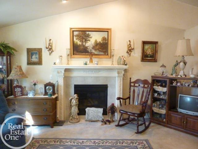 sitting room featuring vaulted ceiling and a tile fireplace