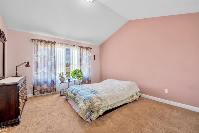 bedroom featuring lofted ceiling, baseboards, and light carpet