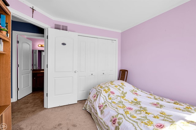 bedroom with carpet flooring, visible vents, and a closet