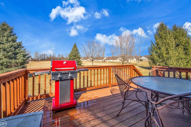 wooden deck with a grill and outdoor dining space