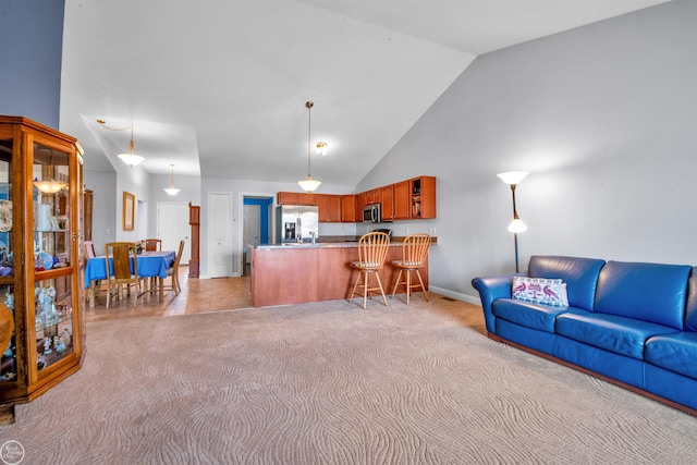 living area with light colored carpet, baseboards, and high vaulted ceiling