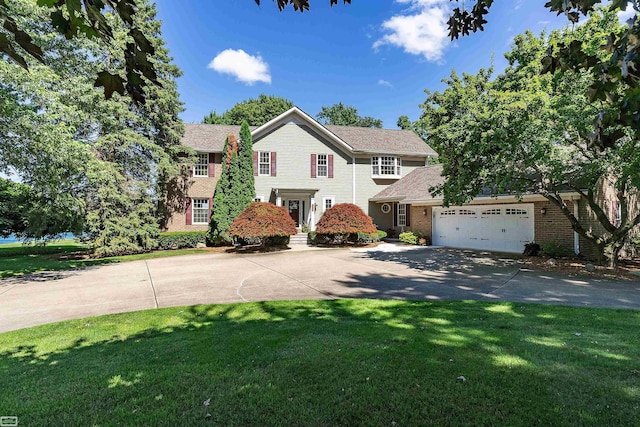 view of front of home featuring a front yard, an attached garage, and driveway