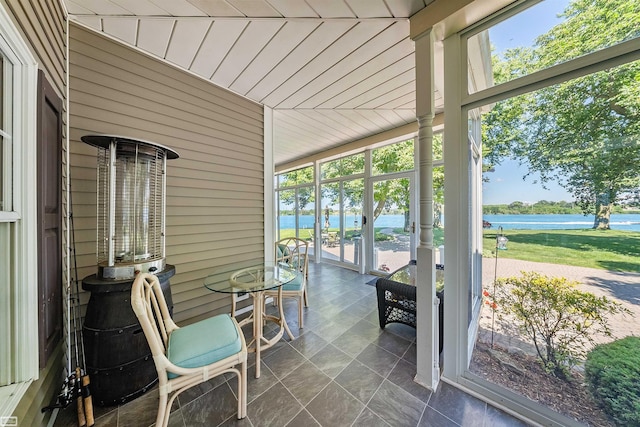 sunroom / solarium featuring a water view and lofted ceiling