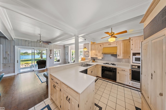 kitchen featuring light brown cabinets, a ceiling fan, under cabinet range hood, white appliances, and a peninsula