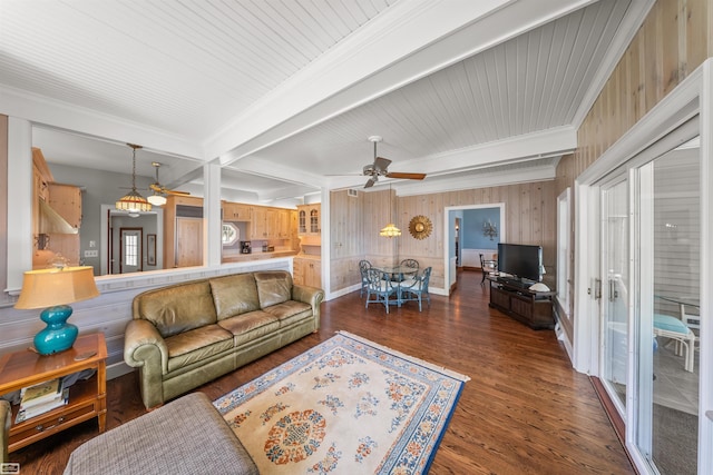 living room featuring crown molding, baseboards, beamed ceiling, wood finished floors, and a ceiling fan