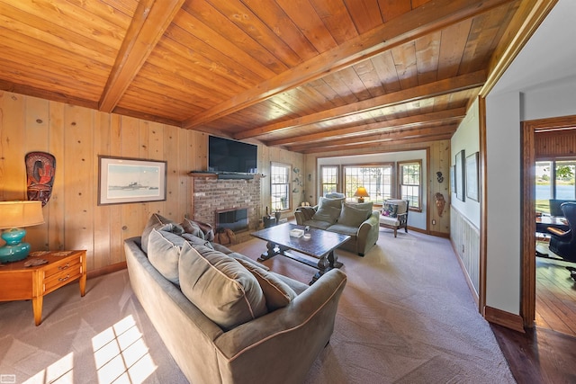 living room with a brick fireplace, beamed ceiling, plenty of natural light, and wooden ceiling