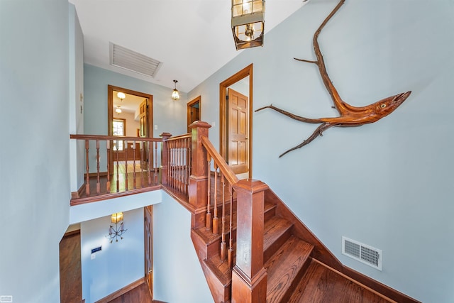 stairway featuring visible vents and wood finished floors