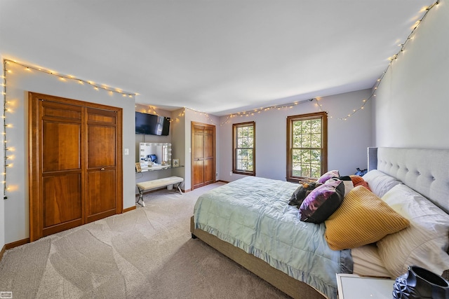 bedroom with light colored carpet, rail lighting, and baseboards