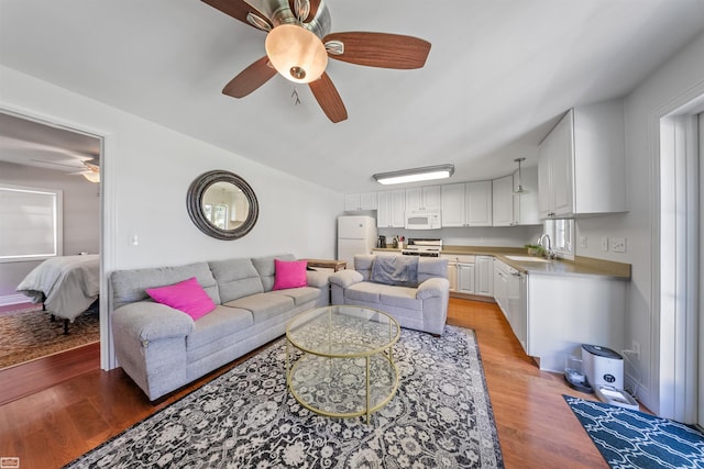 living area with light wood-style flooring and a ceiling fan