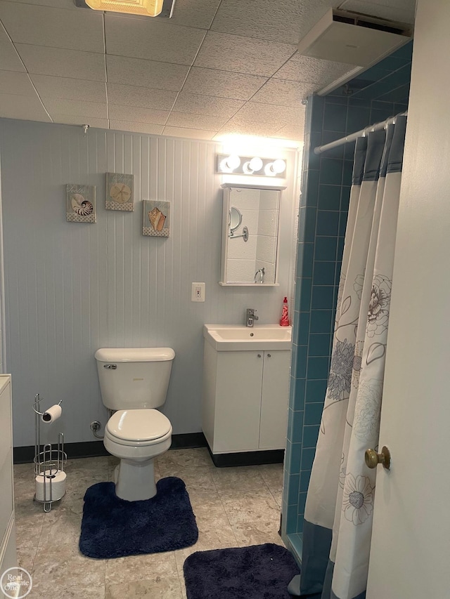 full bathroom featuring vanity, toilet, baseboards, and tiled shower