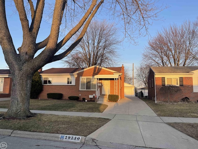 view of front of property with an outbuilding, brick siding, a chimney, and a front yard