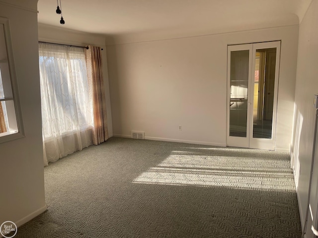 spare room featuring visible vents, carpet floors, and baseboards