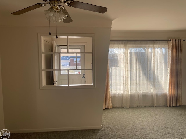 spare room with carpet floors and a ceiling fan