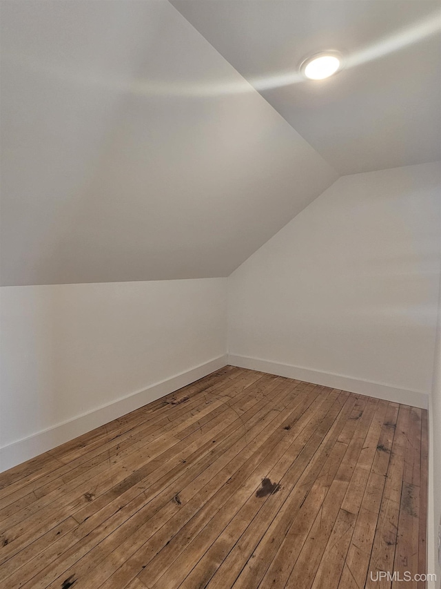 bonus room featuring baseboards, lofted ceiling, and wood-type flooring