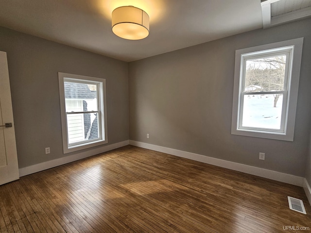 unfurnished room featuring a healthy amount of sunlight, visible vents, and baseboards