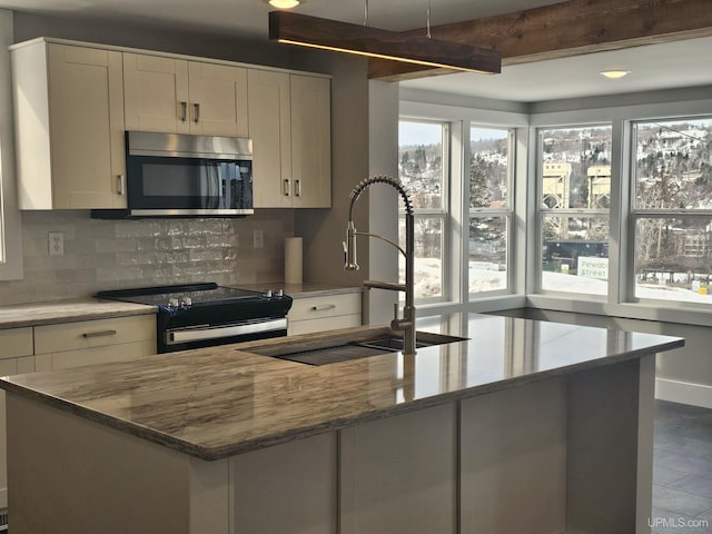 kitchen with range with electric cooktop, a sink, stainless steel microwave, decorative backsplash, and light stone countertops