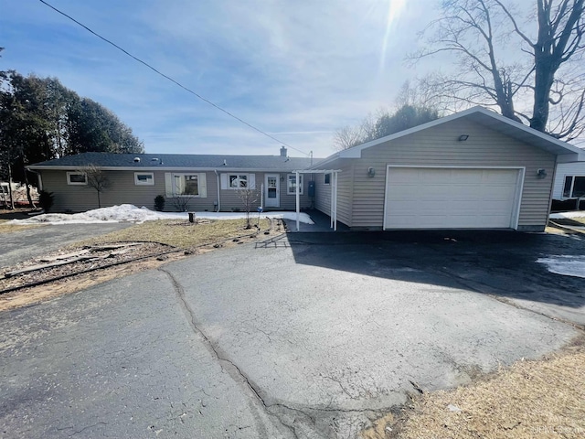 view of front facade with aphalt driveway and an attached garage