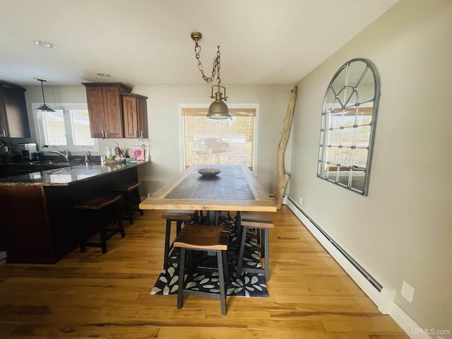 dining room with light wood finished floors and baseboard heating