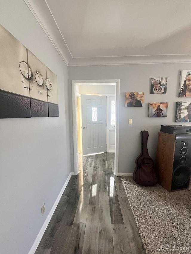 corridor featuring baseboards, dark wood-style flooring, and crown molding