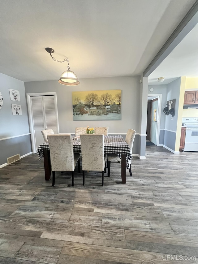 dining area with visible vents, baseboards, and wood finished floors