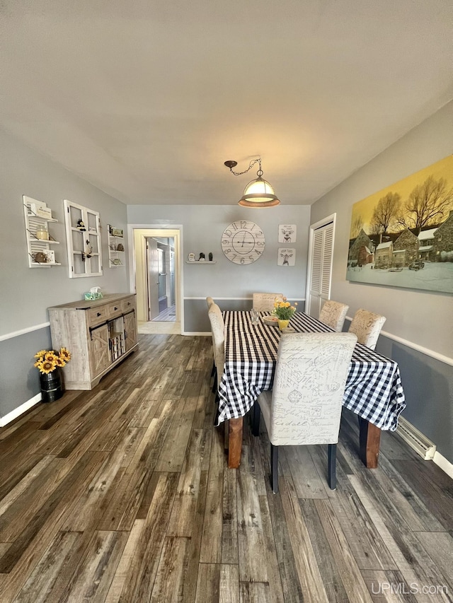 dining room featuring dark wood-style floors and baseboards