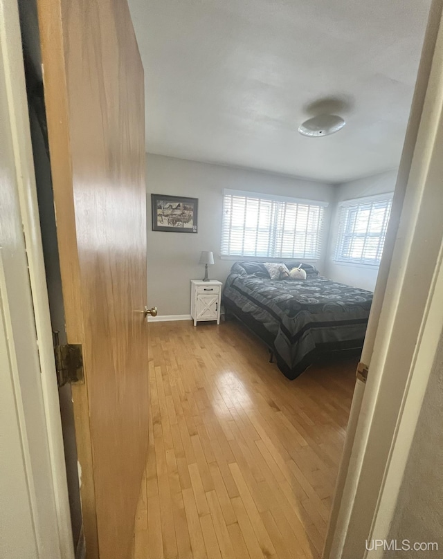 bedroom featuring baseboards and wood-type flooring