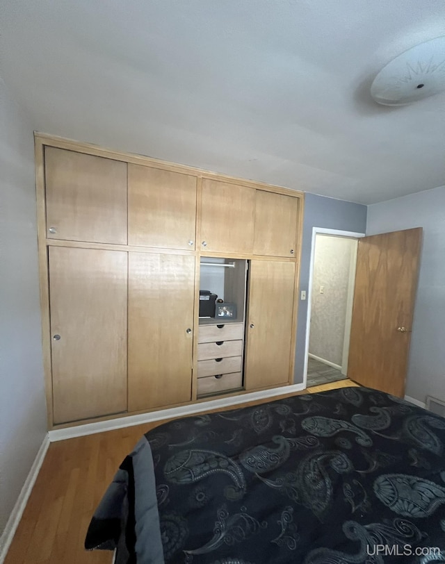 bedroom with wood finished floors and baseboards