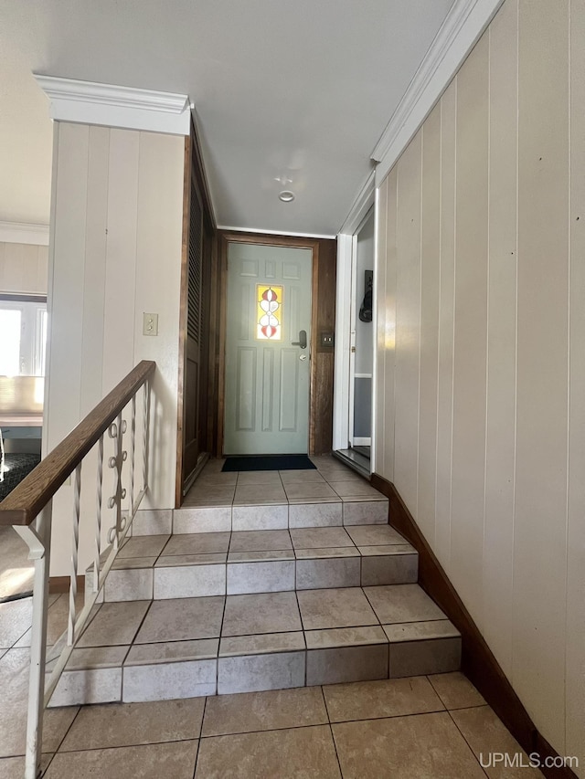 interior space featuring tile patterned flooring, crown molding, and baseboards