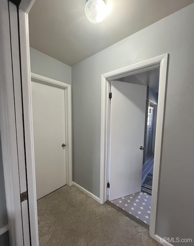 hall featuring carpet flooring and baseboards